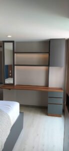 mesa y espejo encapada en la pare en madera con acabado minimalista